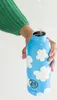 A person is filling a blue water bottle with white cloud patterns with water. Produktbild-Vorschau