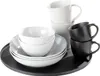 A set of white and black bowls and mugs are arranged on a black tray. Produktbild-Vorschau