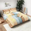 A neatly made bed with colorful patterned bedding and pillows, in a well-lit room with a large plant and artwork. Náhľad obrázku produktu