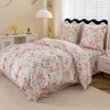 A bedroom scene with a bed made up with a floral and butterfly patterned duvet cover and pillowcases. Produktbild-Vorschau