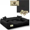 A black dog bed with two small pillows, shown with several brand tags and a textured black material sample in the background. Produktbild-Vorschau