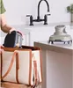 A person is placing a small appliance into a tote bag in a kitchen setting. Anteprima dell’immagine prodotto