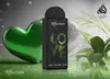 A perfume bottle is displayed with decorative elements like a green heart and plants. Voir les images du produit