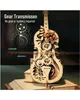 A 3D wooden model of a cello with visible gears and decorative elements, placed on top of a stack of books. Náhľad obrázku produktu