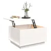 A white wooden coffee table with its top lifted by hydraulic arms, revealing storage space inside. A book and a vase with flowers are placed on the table. Voir les images du produit