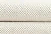 A close-up view of a cream-colored rug with a textured, looped surface. Anteprima dell’immagine prodotto