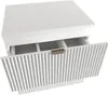 A white vanity cabinet with a ribbed front and an open drawer, revealing compartments inside. A gold handle is visible on the drawer. Produktbild-Vorschau