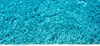 A close-up view of a shaggy turquoise rug. Produktbild-Vorschau