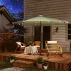 A patio deck at night with outdoor furniture and a lit umbrella. Produktbild-Vorschau