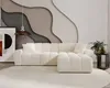 A modern living room with a cream sectional sofa, abstract wall art, and a pendant light. Náhled obrázku produktu