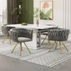 A dining room set with a white table and four gray chairs with gold legs. Produktbild-Vorschau