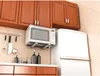 A kitchen scene with cabinets, a microwave, a refrigerator, and various kitchen items. Náhľad obrázku produktu