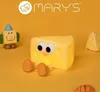 A whimsical scene featuring a cheese-shaped night light with cartoon eyes and legs, accompanied by other small toy-like figures, set against a plain yellow background. Podgląd zdjęcia produktu