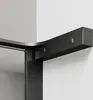 A close-up view of a black shower enclosure corner with a curved metal trim and silver fasteners, against a white wall. Produktbild-Vorschau
