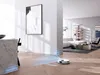 A robot vacuum cleaner is shown cleaning a modern living room with wooden floors and contemporary furniture. Voir les images du produit