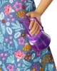 A close-up of a doll's hand holding a purple bottle. Podgląd zdjęcia produktu