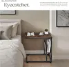 A bedside table next to a bed, with a book and a cup of coffee on it. Náhled obrázku produktu