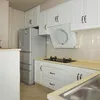 A kitchen with white cabinets, a stainless steel refrigerator, and a gas stove. Produktbild-Vorschau