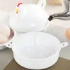 Water is being poured into a white, chicken-shaped container, with eggs visible in a metal insert nearby. Produktbild-Vorschau