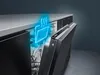 A close-up, angled view of an open dishwasher with a blue neon graphic overlay indicating heat or steam. The dishwasher is built-in under a countertop. Produktbild-Vorschau