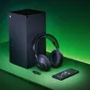 A gaming console, headphones, and a smartphone are arranged on a green surface with a green background. Produktbild-Vorschau