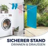 A clothes drying rack with laundry is shown next to a washing machine, with a garden scene in the background. Produktbild-Vorschau