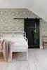 A bedroom with floral wallpaper, a bed, and a sliding barn door. Produktbild-Vorschau