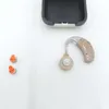 A hearing aid and accessories are laid out on a white surface. Produktbild-Vorschau