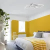 A bedroom with yellow walls, a bed with white bedding and a yellow throw, and a modern ceiling light. Produktbild-Vorschau
