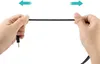 Hands stretching a black audio cable. Anteprima dell’immagine prodotto