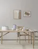 A dining table set with a pitcher, bowls, and a newspaper, in a minimalist setting. Produktbild-Vorschau
