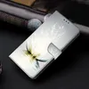 A close-up shot of a phone case with a lotus flower design, placed on a dark surface next to a watch. Produktbild-Vorschau