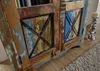 A close-up view of a rustic, multi-colored wooden cabinet with metal accents. Anteprima dell’immagine prodotto