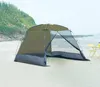 A tent set up on a sandy beach with the ocean and a grassy hill in the background. Náhled obrázku produktu