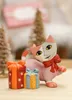 A ceramic cat figurine with two gift boxes in a festive setting. Produktbild-Vorschau