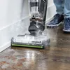 A person is using a BISSELL CrossWave Hydrosteam PET Select vacuum cleaner on a wooden floor. Voir les images du produit