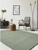 A modern living room scene with a rug, armchair, side table, and artwork. Produktbild-Vorschau