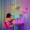 A young girl is sitting at a desk, drawing, with colorful LED lights decorating the wall behind her. Náhled obrázku produktu