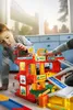 Two children playing with a toy garage and car set indoors. Produktbild-Vorschau