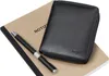A black leather wallet and a pen are placed on top of a notebook. Produktbild-Vorschau