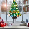 A felt Christmas tree decoration with various ornaments attached, displayed on a window with a snowy outdoor scene visible. Produktbild-Vorschau