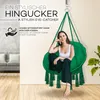 A woman sits in a green hanging chair indoors, with text overlays highlighting its features. Podgląd zdjęcia produktu