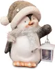 A decorative penguin figurine wearing a hat and scarf, holding a lantern. Produktbild-Vorschau