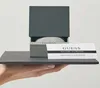 A hand holding a Guess watch box and guarantee card. Produktbild-Vorschau
