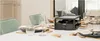 A raclette grill is set up on a dining table, ready for use, with place settings for multiple people. Produktbild-Vorschau