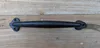 A black metal door handle is placed on a wooden surface. Produktbild-Vorschau