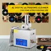 A digital ultrasonic cleaner for vinyl records is shown in front of a wall decorated with album covers and vinyl records. A turntable with a record is also visible on the right side of the image. Anteprima dell’immagine prodotto