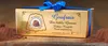A golden gift box of Goufrais cocoa confections, tied with a blue ribbon, sits on a wooden surface dusted with cocoa powder. Náhľad obrázku produktu