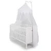A white baby crib with a white mosquito net canopy and a silver stand. Produktbild-Vorschau