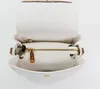 An open white handbag with brown trim and gold hardware, viewed from above. Náhľad obrázku produktu